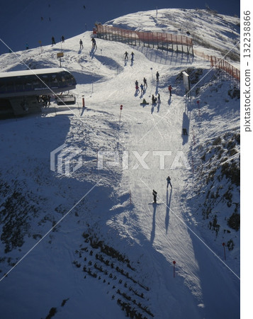 A ski slope with a lot of people skiing down it A ski slope with a lot of people skiing down it 132238866