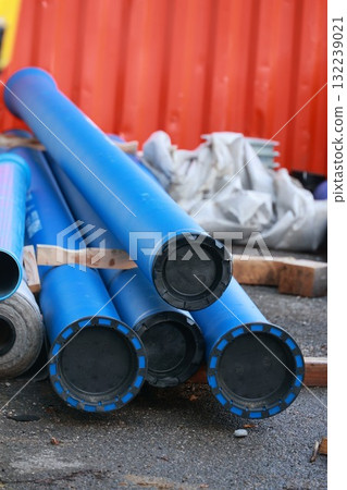 Pile of blue pipes with black caps 132239021