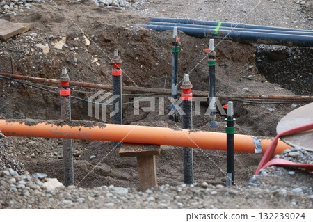 Construction site with a large orange cable running through it 132239024