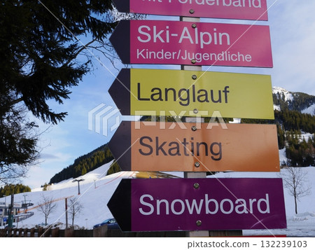 Signboard with a row of arrows pointing to different activities such as skiing Signboard with a row of arrows pointing to different activities such as skiing 132239103