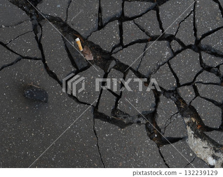 Broken sidewalk with a cigarette butt on it Broken sidewalk with a cigarette butt on it 132239129