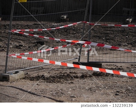 Red and white striped rope is tied to a metal fence 132239139