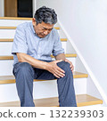 一名膝蓋疼痛的中年男子在家中的樓梯上抱住膝蓋 132239303