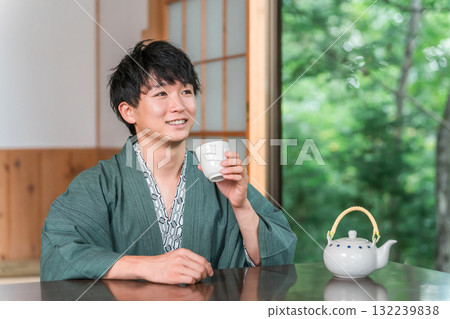 身著浴衣的亞洲年輕女子在日式旅館的房間喝茶 身著浴衣的亞洲年輕女子在日式旅館的房間喝茶 132239838