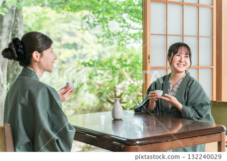 Women and friends drinking sake in yukata on the veranda of a Japanese-style room in a Japanese inn 132240029