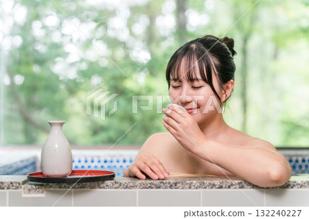Young Asian woman drinking sake while taking a bath in a hot spring 132240227