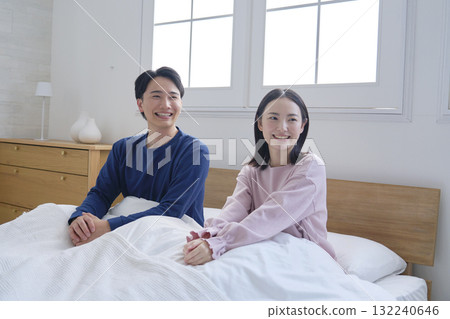 一對夫婦在床上醒來，看著相機的肖像 132240646