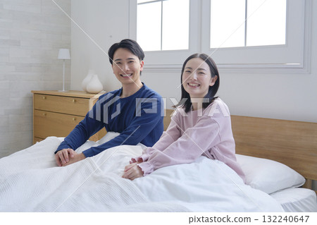 一對夫婦在床上醒來，看著相機的肖像 132240647