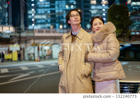 Men and women standing in the city at night 132240773