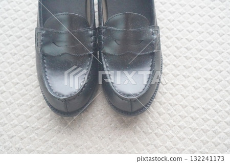 A close-up photo of the toe area of a black loafer. A close-up photo of the toe area of a black loafer. 132241173