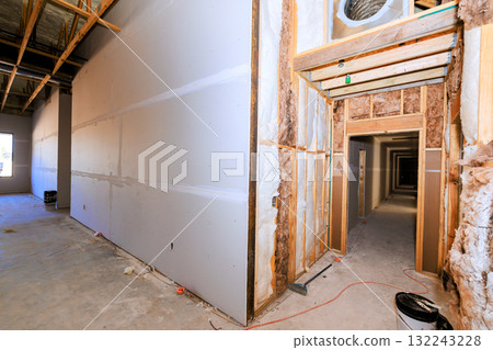Drywall installation is ongoing, an empty commercial space hallways under construction 132243228