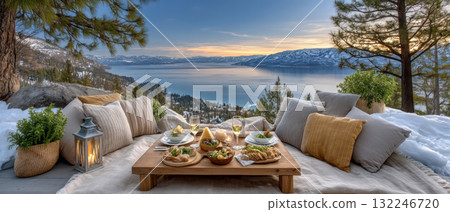 Cozy winter picnic with low table pillows lantern and lake view at sunset 132246720
