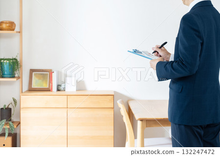 A man in a suit checking furniture A man in a suit checking furniture 132247472