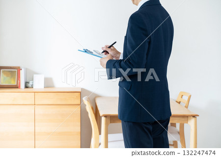 一名西裝革履的男子正在檢查家具 132247474