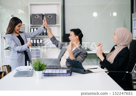 Group of young Asian business people discussing business plan at modern startup in creative business discussing work 132247681