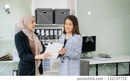 Two businesswoman and man discuss investment project working and planning strategy with tablet laptop computer Two businesswoman and man discuss investment project working and planning strategy with tablet laptop computer 132247726