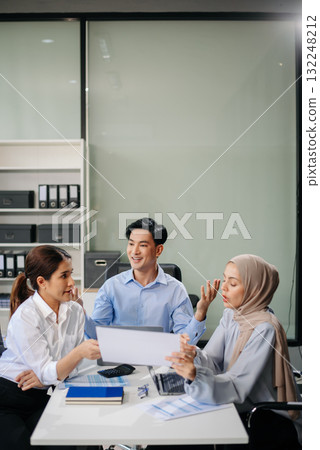 Office colleagues have a casual discussion. During a meeting in a conference room, a group of business teem 132248212