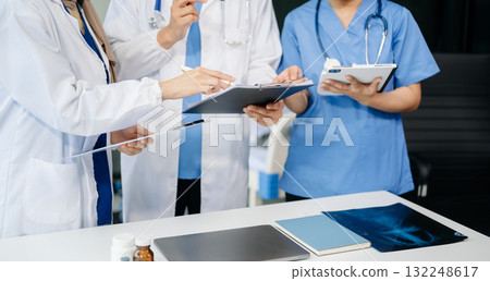 Medical professionals in modern clinic, discussing treatment and prescriptions. Healthcare, teamwork, consultation, diagnosis, and therapy and people team Medical professionals in modern clinic, discussing treatment and prescriptions. Healthcare, teamwork, consultation, diagnosis, and therapy and people team 132248617