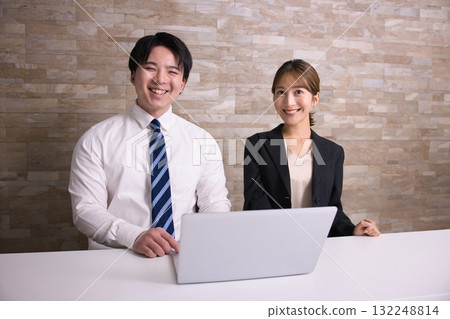 辦公室裡並肩坐著微笑的商務人士 辦公室裡並肩坐著微笑的商務人士 132248814