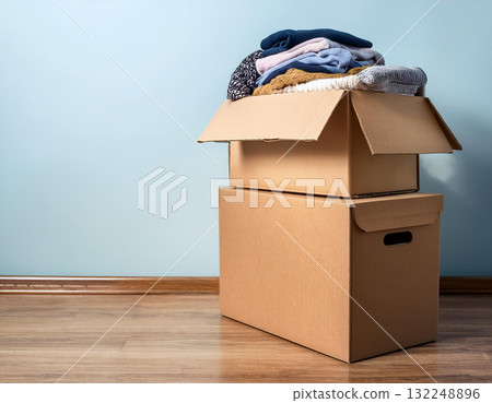 Cardboard boxes filled with clothes 132248896
