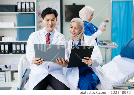 Medical professionals in modern hospital collaborating on patient care, research, and diagnosis. Doctors and nurses in hijabs discussing treatment plans, lab Medical professionals in modern hospital collaborating on patient care, research, and diagnosis. Doctors and nurses in hijabs discussing treatment plans, lab 132248973