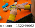 Assemble a fish using cardboard, thread, and paint, with clear instructions, against an orange background. 132249062