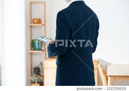 一名西裝革履的男子正在檢查家具 132250029