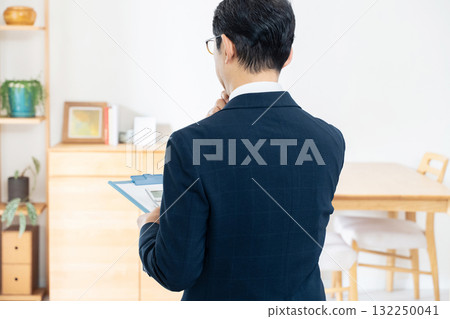 A man in a suit checking furniture A man in a suit checking furniture 132250041