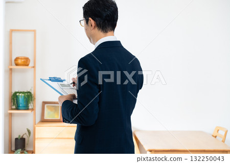 一名西裝革履的男子正在檢查家具 132250043