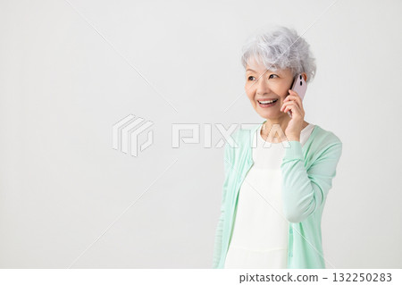 一位資深女性用智慧型手機打電話 一位資深女性用智慧型手機打電話 132250283