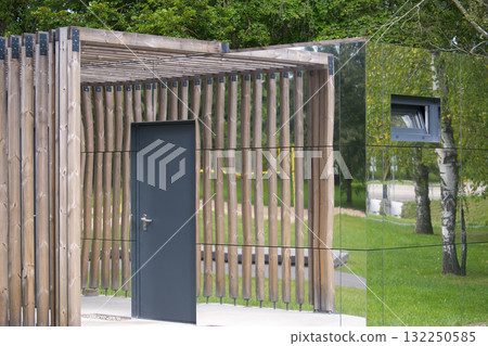 Modern architectural structure with wooden elements and reflective surfaces. 132250585