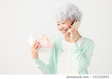 高級女性高興收到智慧型手機禮物 高級女性高興收到智慧型手機禮物 132250835