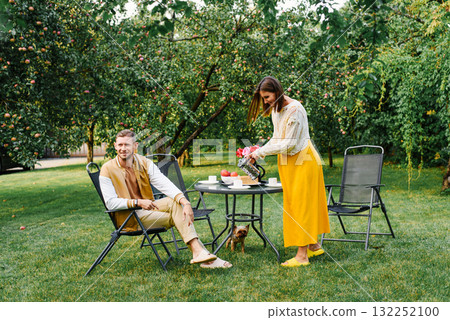 Family Drinking Tea Together In Sunny Garden 132252100