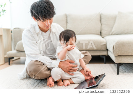 父親在家裡的客廳和他的孩子和嬰兒玩耍（育兒、養育、肌膚接觸） 132252296