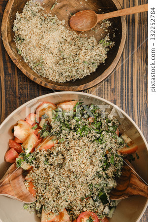 Fresh salad with herbs and nuts served in a wooden bowl during a sunny outdoor gathering Fresh salad with herbs and nuts served in a wooden bowl during a sunny outdoor gathering 132252784