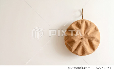 象牙色的牆上掛著一頂米色的貝雷帽，一幅樸素而寧靜的日常生活場景 132252934