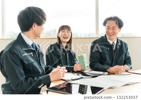 身著工作服的男女商人一邊開會一邊觀看建築模型 身著工作服的男女商人一邊開會一邊觀看建築模型 132253037