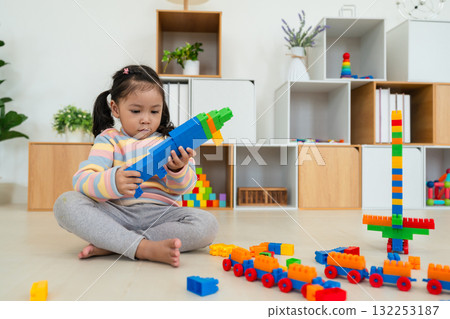 toddler girl playing building blocks or plastic bricks toy at home toddler girl playing building blocks or plastic bricks toy at home 132253187