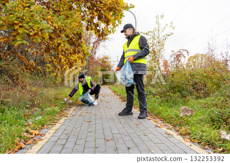 Volunteers Collecting Garbage in Park in Autumn Volunteers Collecting Garbage in Park in Autumn 132253392
