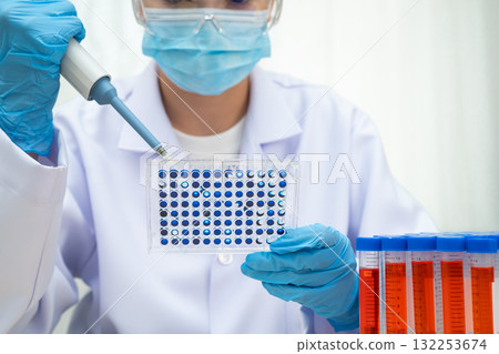 Scientist with cell culture in sample micro plate for research in science laboratory. Scientist with cell culture in sample micro plate for research in science laboratory. 132253674