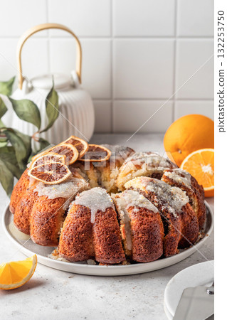Orange and chocolate marble bundt cake with sugar icing. Fruity citrus dessert on light gray kitchen background Orange and chocolate marble bundt cake with sugar icing. Fruity citrus dessert on light gray kitchen background 132253750