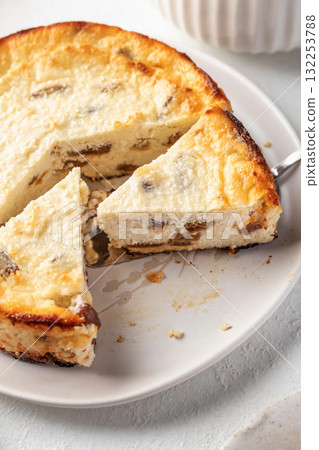 Homemade cottage cheese casserole pie with raisins close up. Baked cheesecake for healthy breakfast on white table background 132253788