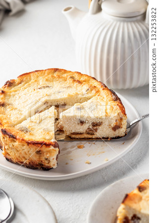 Homemade cottage cheese casserole pie with raisins. Baked cheesecake for healthy breakfast on white table background 132253822