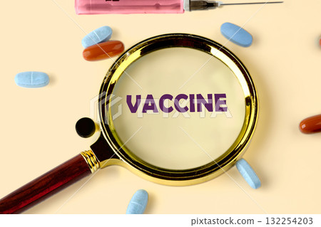 A magnifying glass focuses on the word vaccine, surrounded by colorful pills and a syringe. This scene emphasizes the significance of vaccinations in health and wellness A magnifying glass focuses on the word vaccine, surrounded by colorful pills and a syringe. This scene emphasizes the significance of vaccinations in health and wellness 132254203