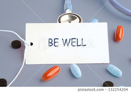 A card with the phrase Be Well rests at the center of assorted pills in different colors, featuring a stethoscope that signifies health and wellness, inspiring positive thoughts A card with the phrase Be Well rests at the center of assorted pills in different colors, featuring a stethoscope that signifies health and wellness, inspiring positive thoughts 132254204