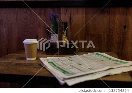 An open magazine and coffee in a corner of an empty cafe An open magazine and coffee in a corner of an empty cafe 132254234