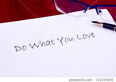 On a clean desk, a note with the words Do What You Love is placed beside a pen and a pair of glasses, creating a motivating scene for creativity and purpose On a clean desk, a note with the words Do What You Love is placed beside a pen and a pair of glasses, creating a motivating scene for creativity and purpose 132254265