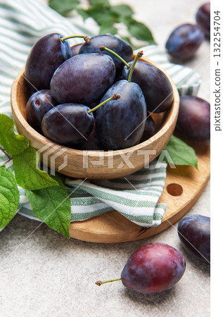 Fresh ripe plums filling a wooden bowl 132254704