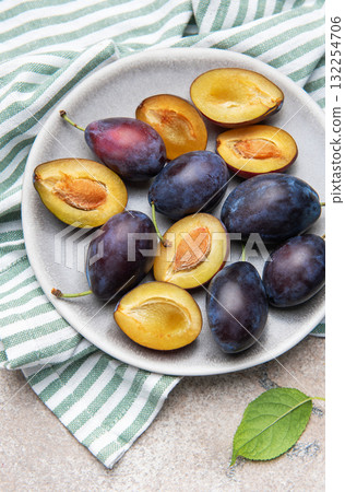 Fresh ripe plums with halves on plate for healthy eating 132254706