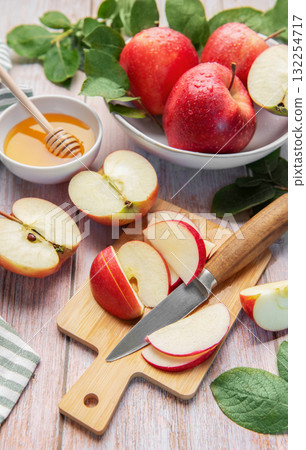 Sliced red apples and honey on wooden table 132254717